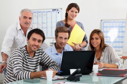 Colaboradores de una empresa sonriendo en una junta de trabajo